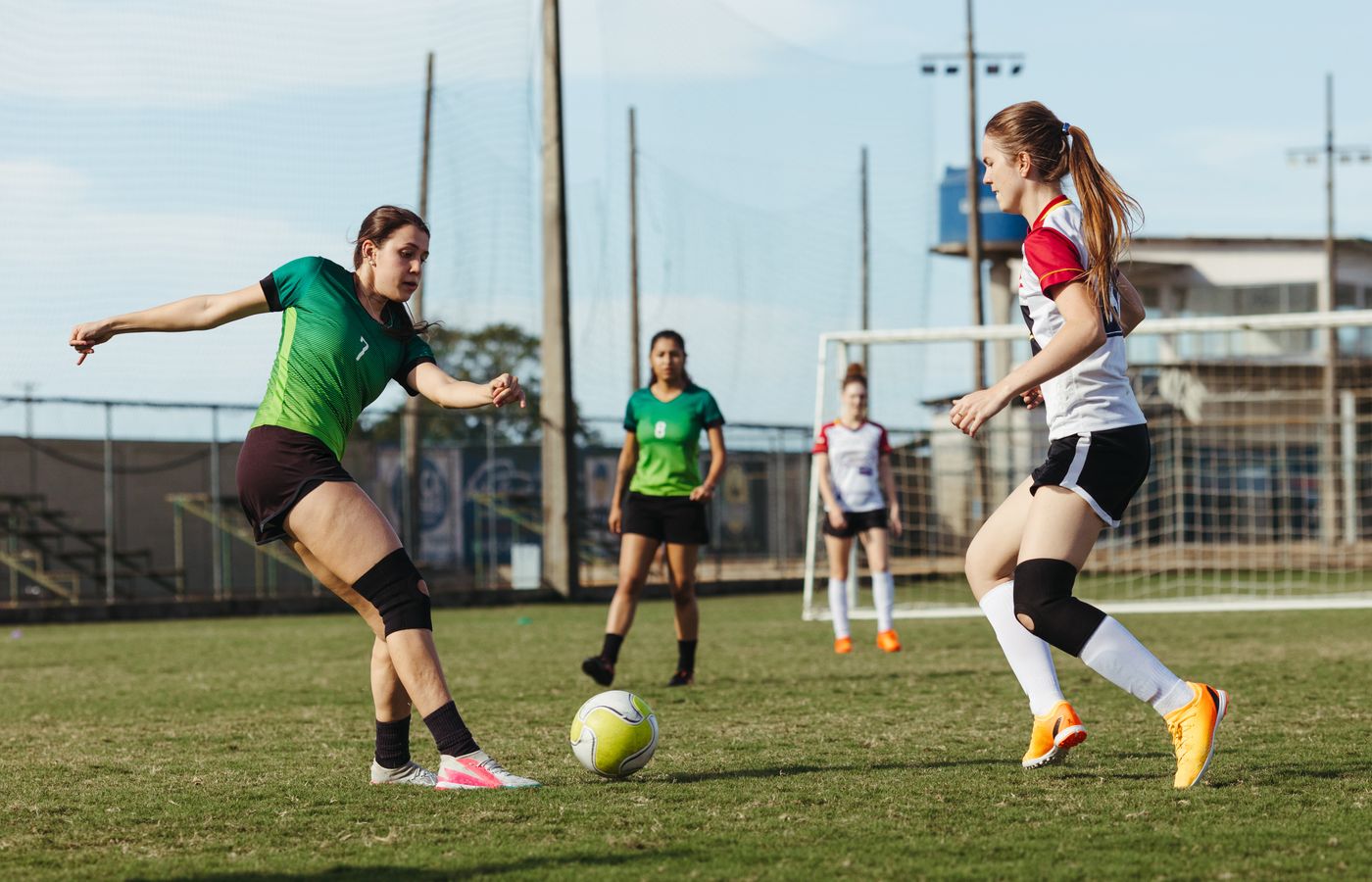 Jogadoras disputam uma partida de futebol